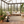 Modern conservatory with rattan furniture, plants, and a rug featuring Meow Mews Luna raised cat bed in black